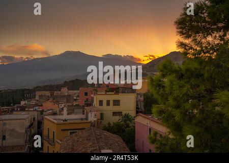 Vista della città di Taomina e del lontano Etna al tramonto, Taormina, Sicilia, Italia, Europa Foto Stock