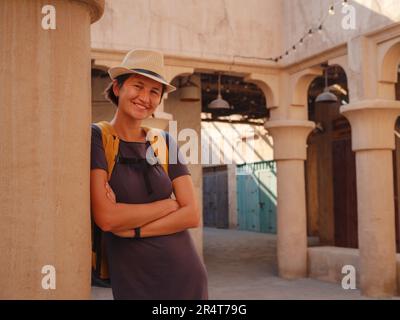 Gita turistica alla vecchia Dubai, Emirati Arabi Uniti. Asian Woman turista in vecchie stradine strette di Bur Dubai e Creek, al Seef Heritage Souq. Concetto di viaggio e di viaggio turistico Foto Stock