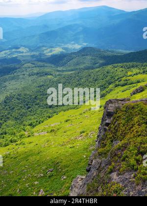 colmo di spartiacque carpazi. pietre e massi sulle verdi colline erbose. vista aperta su montagne lontane. caldo giorno d'estate Foto Stock