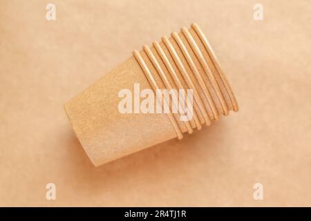 Concetto di assenza di plastica e zero sprechi. Vasetti di carta monouso su sfondo marrone, vista dall'alto Foto Stock