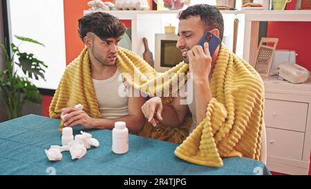 Due coppie di uomini che hanno una consulenza medica telefono in sala da pranzo Foto Stock