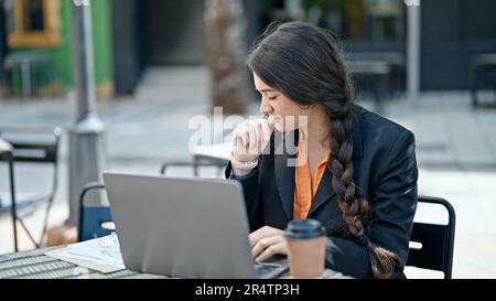 Giovane donna ispanica bella operatrice di lavoro ammalata al bar terrazza Foto Stock