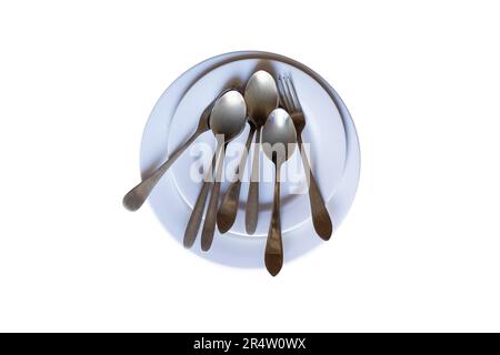 Piatti bianchi con cucchiaio e tavolo a forchetta su fondo bianco isolato Foto Stock