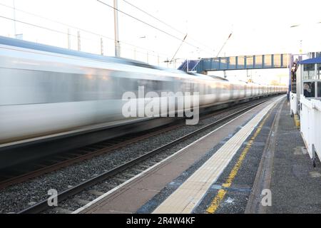 Un treno color argento passa attraverso Hendon Station North London creando una sfocatura mentre si dirige verso nord sulla strada per St Albans. Foto Stock