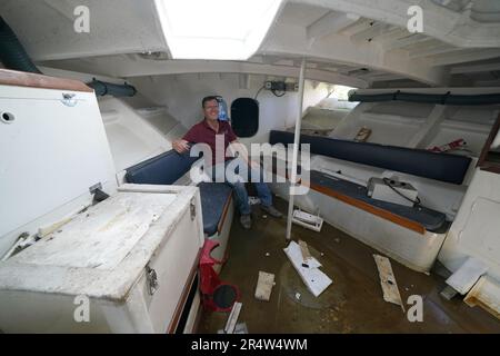 Martyn Steedman nella cabina dei superstiti di fronte a bordo di un'ex scialuppa di salvataggio RNLI dopo essere stato abbassato nel suo campeggio presso la Mains Farm di Thornhill, Stirlingshire, dove la nave Tyne Class da 26 tonnellate sarà trasformata in un baccello glamping. Data immagine: Martedì 30 maggio 2023. Foto Stock