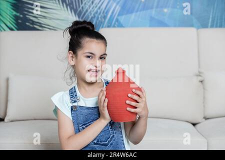 Bambino che mostra il suo Piggy verso la macchina fotografica con espressione felice. concetto di investimento Foto Stock