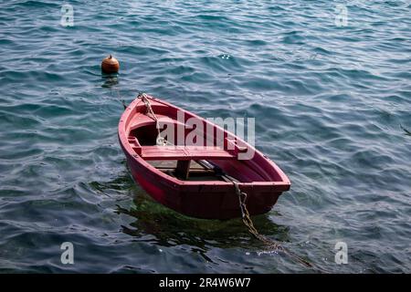 Una piccola barca rossa solitaria Foto Stock