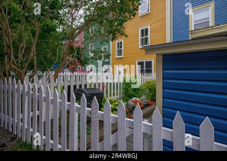 L'esterno di più case colorate adiacenti in legno con finestre a doppia appesa. Gli edifici adiacenti sono rossi, verdi, gialli e blu. Foto Stock