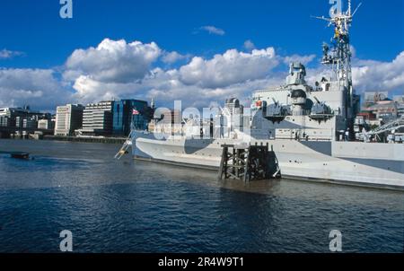 La vista degli anni '90 dell'HMS Belfast ormeggiata nel Tamigi vicino al Tower Bridge London England Foto Stock