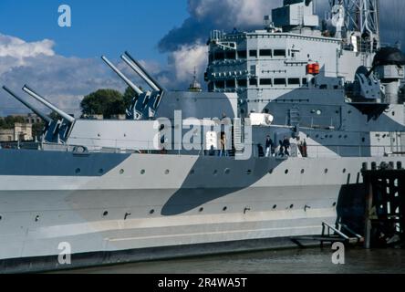 La vista degli anni '90 dell'HMS Belfast ormeggiata nel Tamigi vicino al Tower Bridge London England Foto Stock