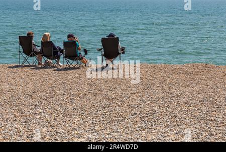 Persone che si rilassano sulla spiaggia di Seaton a Seaton, Devon, Regno Unito nel mese di maggio Foto Stock