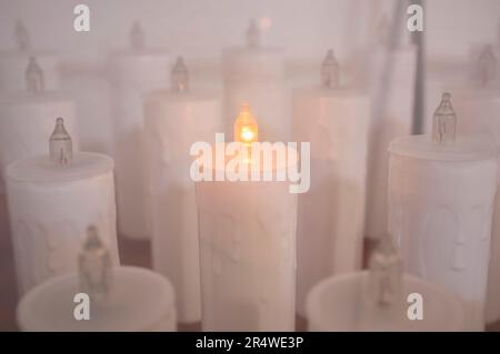 Candele elettriche senza fiamma. Mettere a fuoco l'unica luce accesa Foto Stock