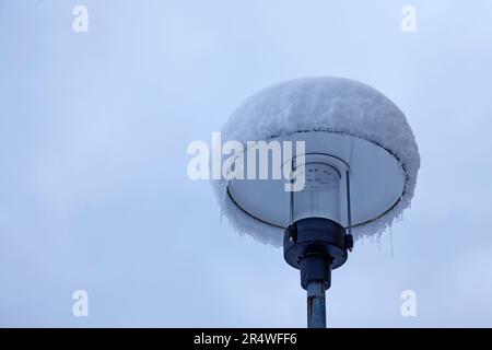 lampione coperto di neve e ghiaccio in inverno Foto Stock