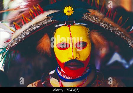 Papua Nuova Guinea. Ritratto di tribesman locale con volto dipinto e headdress tradizionale. Foto Stock