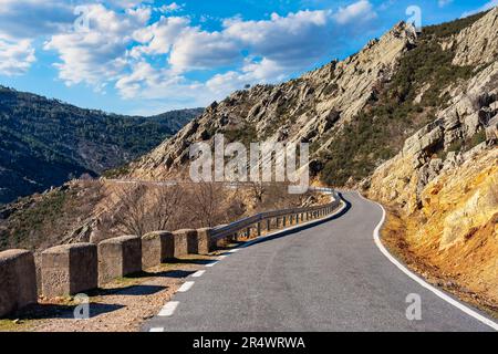 Strada di montagna tra formazioni rocciose di forme stravaganti nella Sierra del Rincon, Madrid. Foto Stock