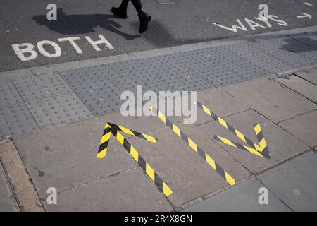 I resti della pandemia di Covid sono visti sul marciapiede accanto alla scritta stencil per entrambi i sensi che attraversano la Blackfriars Bridge Road a Southwark, Londra del sud, il 23rd maggio 2023, a Londra, Inghilterra. Foto Stock