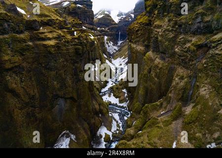 Un paradiso per escursionisti, il Mulagljufur Canyon con una vista incredibile di un tortuoso fiume di montagna e di una cascata isolata contro le scogliere rocciose Foto Stock