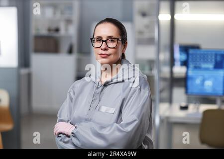 Girovita ritratto di donna che indossa tuta protettiva in laboratorio e guardare la fotocamera, copia spazio Foto Stock
