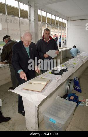 Il doppio campione del mondo motorsport John Surtees OBE torna allo storico circuito Gueux di Formula uno a Reims come parte della Beaujolais Run per la prima volta in 44 anni in una Maserati, che è stata l'ultima vettura che ha guidato al cicruit francese. Surtees firma il libro visitatori per Les Amis du Circuit de Gueux Foto Stock