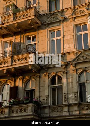 Facciata ornata di costruzione del XIX secolo con balconi e fiori al tramonto; Breslavia, Polonia Foto Stock