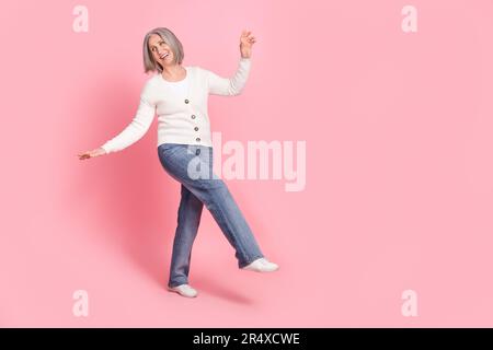 Full size ritratto di spensierato overjoyed anziana signora godere di ballo hanno buon umore vuoto spazio isolato su sfondo di colore rosa Foto Stock