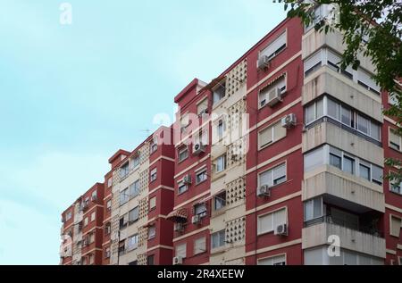 Immagine di alcuni vecchi condomini in una zona residenziale a basso reddito con condizionatori d'aria e ombrelloni sulle finestre Foto Stock