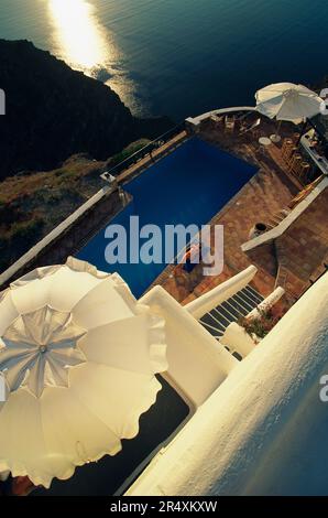 Vista rialzata di una donna che si rilassa in piscina; Santorini, Grecia Foto Stock