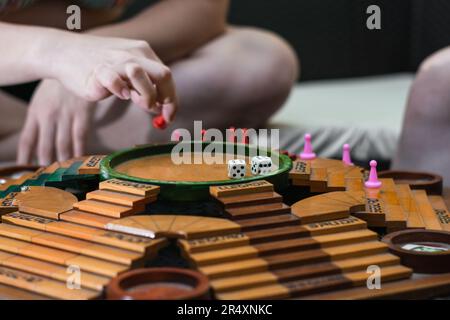 primo piano della mano di una ragazza che sta tenendo il gettone del gioco da tavolo chiamato parchi Foto Stock