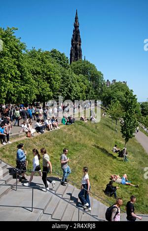 Turisti e locali che godono il sole a Princes Street Gardens, Edimburgo, Scozia, Regno Unito. Foto Stock
