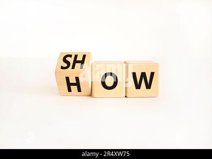Mostra come simbolo. L'uomo d'affari gira i cubi di legno e cambia la parola Mostra a come. Bellissimo sfondo bianco tavolo. Spazio di copia. Business e Sho Foto Stock