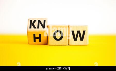 Sapere come simbolo. Uomo d'affari gira cubi di legno e cambia la parola come sapere. Bellissimo sfondo bianco tavolo giallo. Spazio di copia. Business e kN Foto Stock