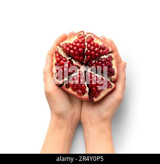 Melograno pelato maturo in mano su uno sfondo bianco vista dall'alto. Un melograno intero con buccia tagliata nelle palme dell'isolamento. Frutti sani. Foto Stock