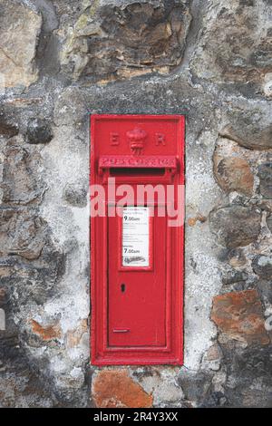 Un classico, vecchio stile, rosso vintage cassetta delle lettere o casella postale utilizzato dalla posta reale costruito in un vecchio muro di pietra nello storico villaggio scozzese di Aberdo Foto Stock