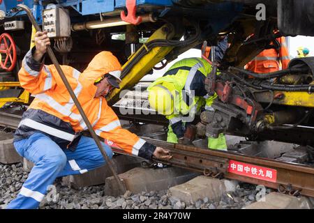 Kunszentmiklos, Ungheria. 30th maggio, 2023. Il 30 maggio 2023 i lavoratori posero una rotaia d'acciaio nel cantiere della ferrovia Budapest-Belgrado di Kunszentmiklos, Ungheria. Sullo sfondo di cieli bui, pioggia battente, tuoni e fulmini, il faticoso compito di posare le rotaie per la sezione costruita dalla Cina in Ungheria del progetto ferroviario Budapest-Belgrado è stato avviato qui martedì, segnando una pietra miliare significativa nel progetto. Credit: Attila Volgyi/Xinhua/Alamy Live News Foto Stock