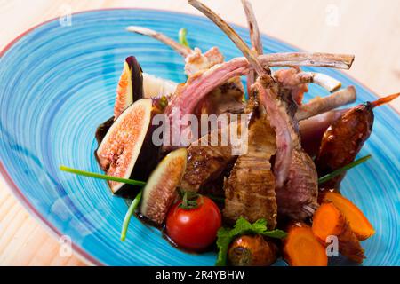 Costolette di montone arrosto con fichi, verdure, salsa demi-glace Foto Stock