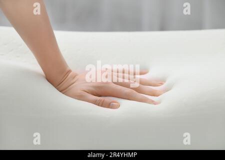 Donna che tocca ortopedico cuscino in schiuma memoria interna, primo piano Foto Stock