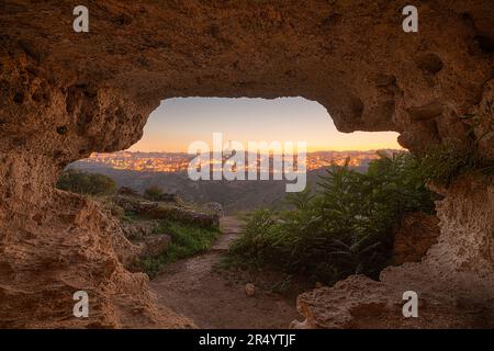 Matera, Italia come si vede dall'interno di un'antica grotta al crepuscolo. Foto Stock