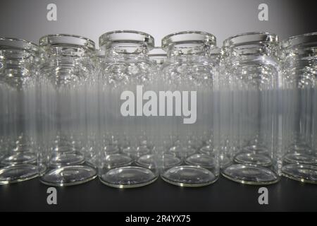Bottiglie di vetro vuote di piccole dimensioni su tavolo nero in laboratorio Foto Stock