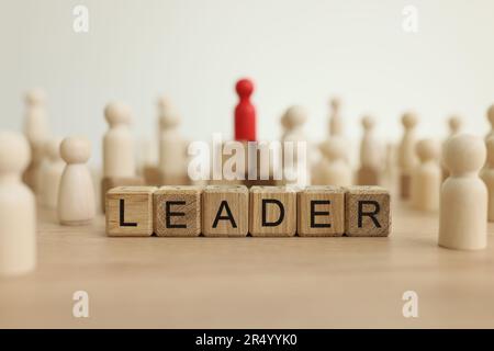 Word leader costruito in cubi di legno contro la figura rossa Foto Stock