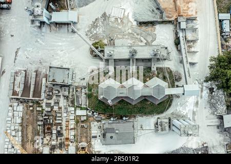 impianto di miscelazione del calcestruzzo. il deposito dell'impianto di dosaggio di calcestruzzo è riempito con vari mucchi di sabbia e ghiaia. vista dall'alto dell'antenna. Foto Stock