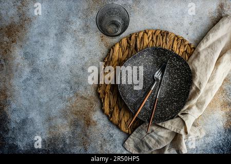 Tavolo minimalista con tovagliolo rustico e gres su tavola di cemento Foto Stock