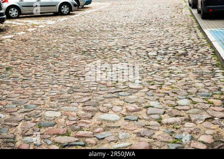 Vista sul vecchio fianco in pietra vicino alle auto. Copertura del sentiero Foto Stock