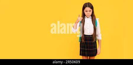 ragazza seria teen con zaino in uniforme scuola intera lunghezza sollevato dito, serietà. Ritratto della studentessa scolastica, intestazione banner studio. Scuola Foto Stock