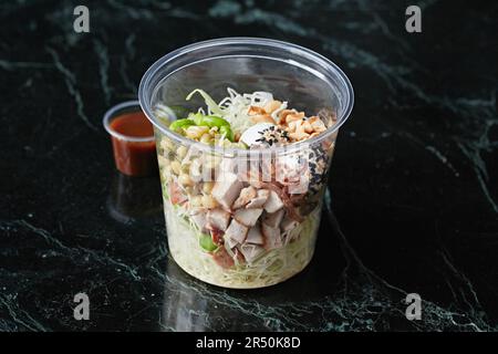 Una sana ciotola con pollo, uova di quaglia e edamame da portare via Foto Stock