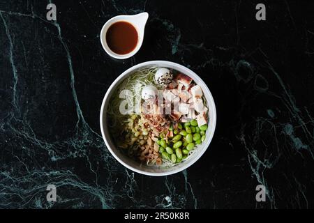 Una ciotola sana con pollo, uova di quaglia e edamame Foto Stock