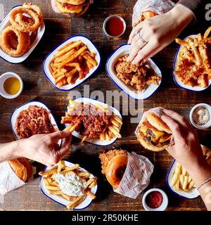 Fast food - cipolle fritte, patatine fritte, hamburger e pepite Foto Stock
