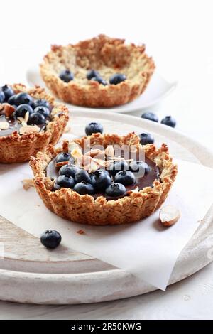 Mousse al cioccolato e tartlet di mirtilli con crosta di avena Foto Stock