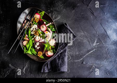 Salubre insalata di spinaci e barbabietole servite in ciotola con formaggio feta e noci Foto Stock