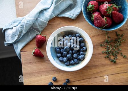 Fragole fresche e mirtilli in ciotole Foto Stock