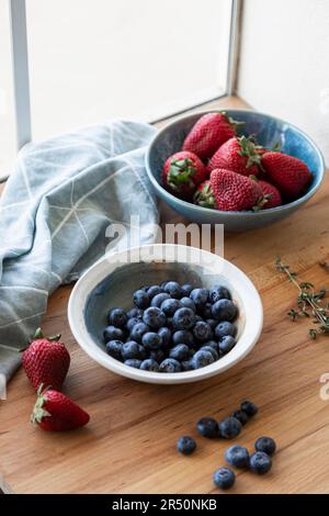 Fragole fresche e mirtilli in ciotole Foto Stock